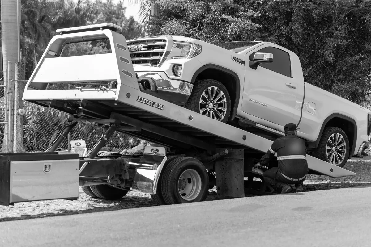 Carro sendo levado por guincho após ordem de busca e apreensão